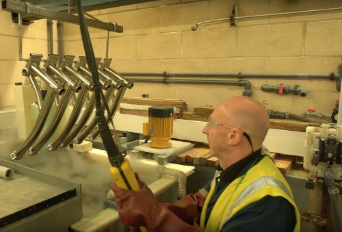 Bicycle frames being electroless nickel plated are lifted out of the tanks at Surface Technology Leeds